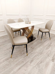 White veined stone dining table with gold pedestal base set with beige chairs