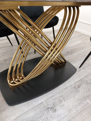 Close view of the dining table's intertwined gold metal supports and dark base