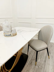 Dining table corner showing white veined stone top and gold base
