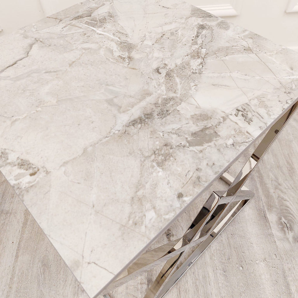 Close view of the lamp table's pale veined stone top and chrome frame