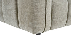 Venice sofa detail showing textured gray upholstery, rounded panel seams, and a short black leg