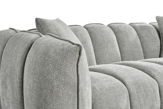 Three-seat sofa detail showing rounded channel back and textured gray upholstery
