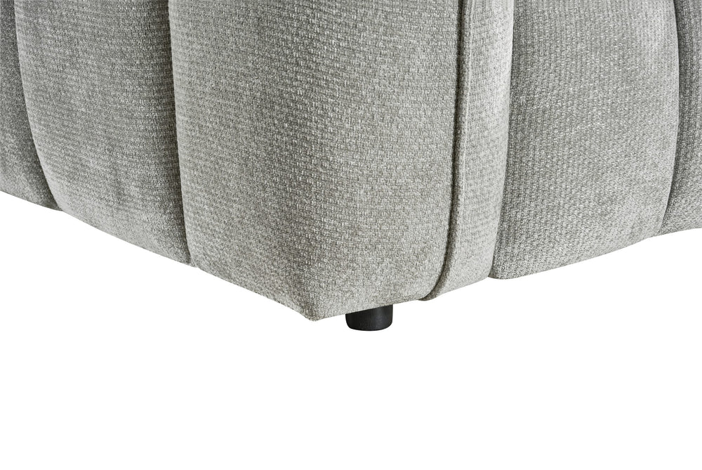 Close-up of the sofa's gray upholstery, rounded panel seams, and black foot