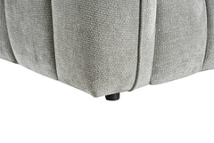 Close-up of the sofa's gray upholstery, rounded panel seams, and black foot