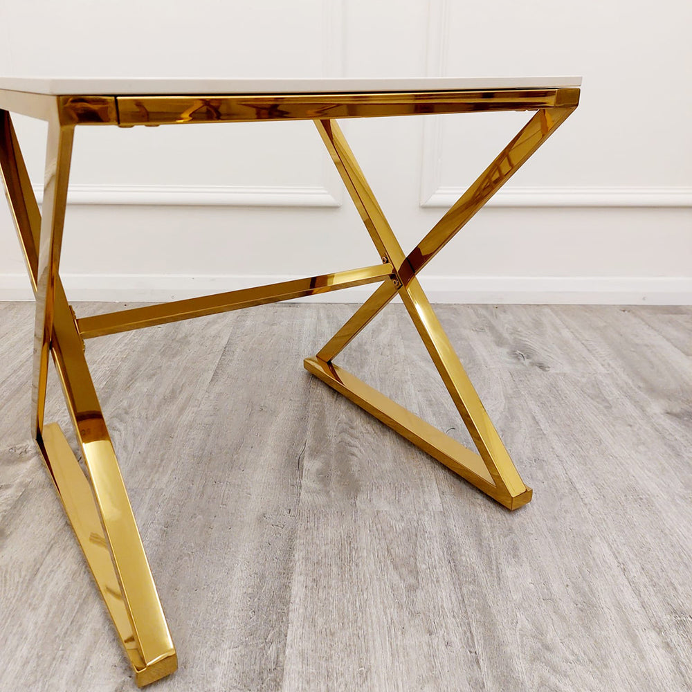 Side view of the table's angular gold metal base and white top