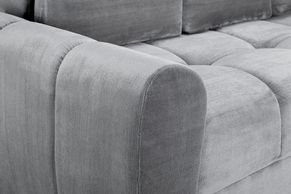 Close-up of the grey sofa bed's rounded armrest and textured upholstery