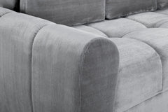 Close-up of the grey sofa bed's rounded armrest and textured upholstery