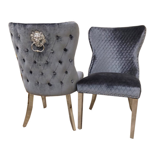 Pair of grey velvet dining chairs with buttoned backs, diamond quilting, lion knockers and metal legs