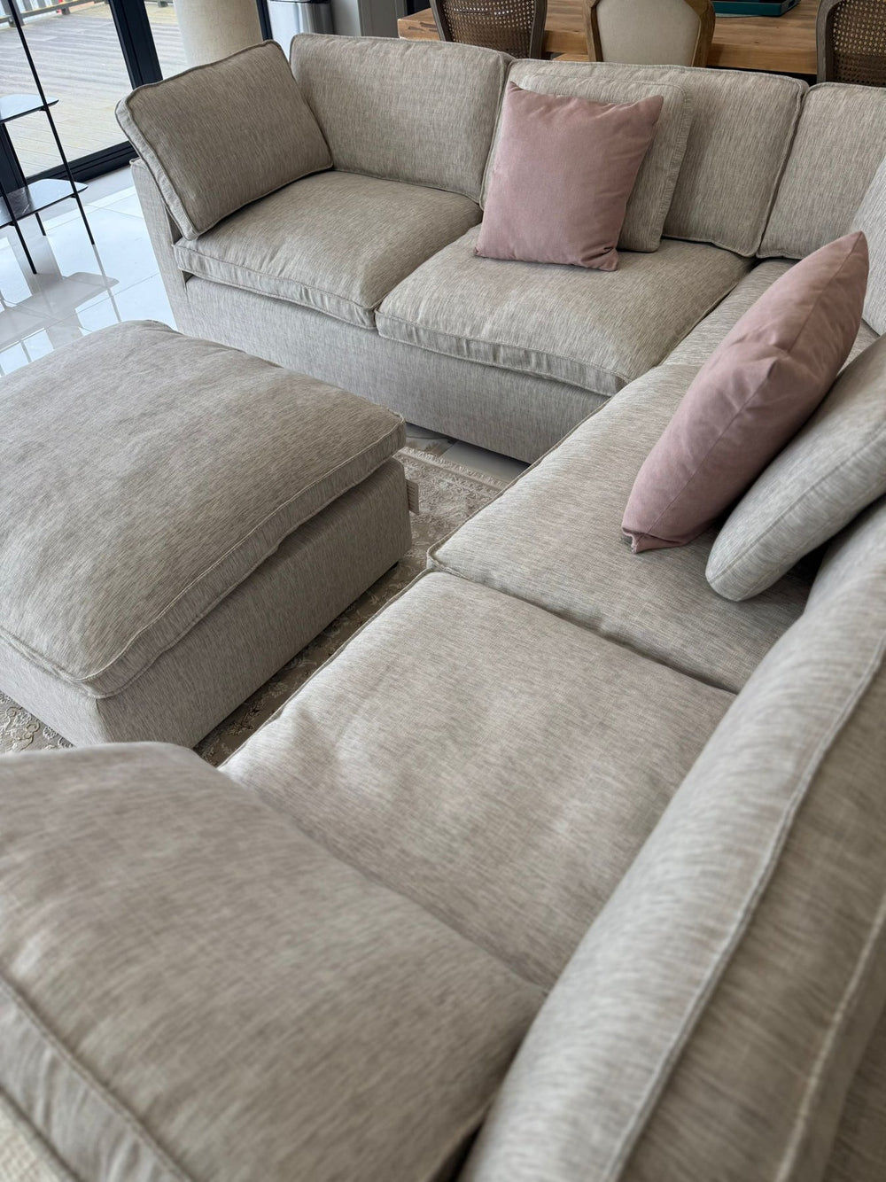 Large corner sofa and matching footstool with cushioned seats