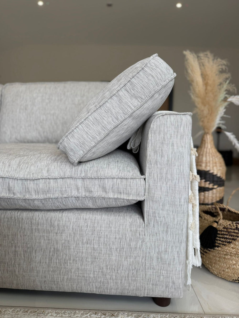 Sofa arm with a loose cushion resting at an angle