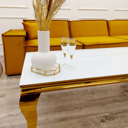 White marble dining table with a reflective gold frame and curved legs