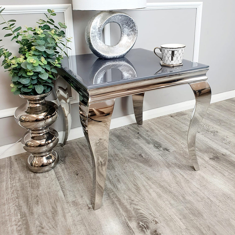 Louis lamp table styled with a reflective top and sculpted silver legs