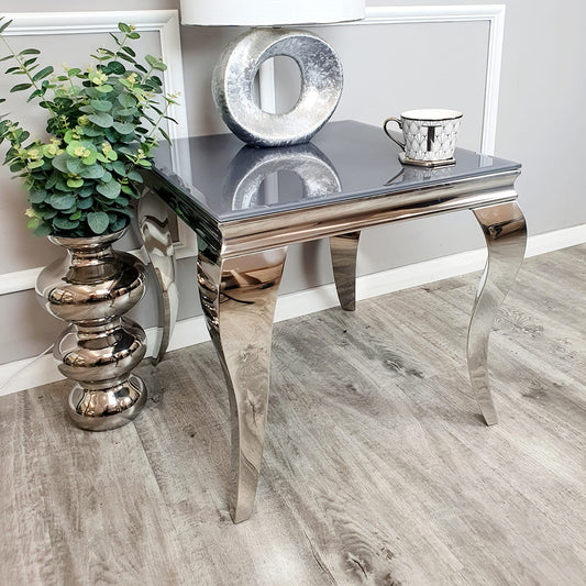Louis lamp table styled with a reflective top and sculpted silver legs