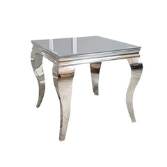 Louis lamp table with a reflective glass top and curved silver legs