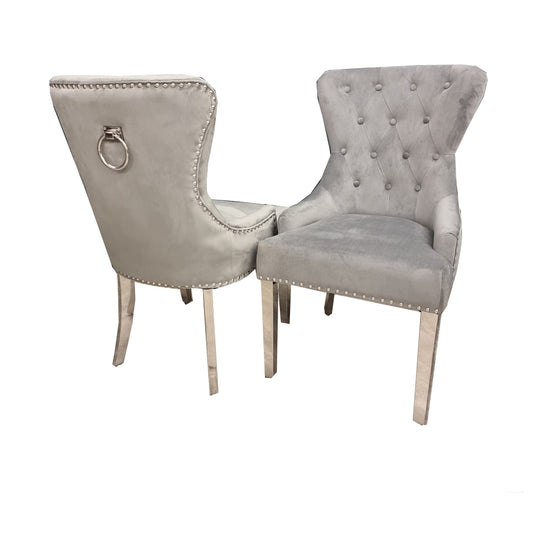 Set of two light gray velvet dining chairs with tufted backs, nailhead trim and metal ring pulls