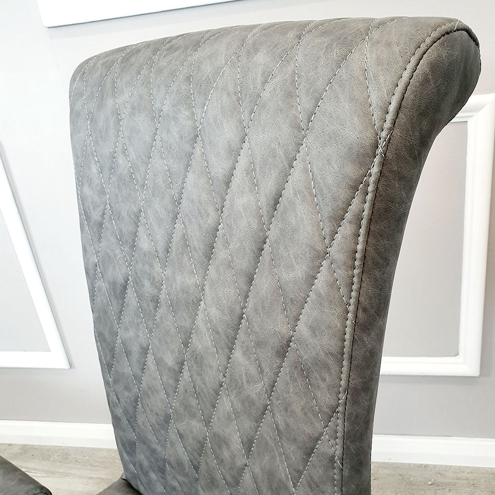 Gray leather dining chair back with diamond cross-stitch quilting and rounded top
