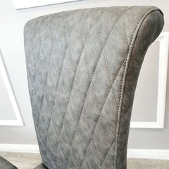 Gray leather dining chair back with diamond cross-stitch quilting and rounded top