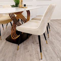 Dining table detail showing a white veined top and layered gold-tone base