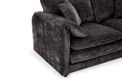 Dark gray corner sofa close-up showing its wide armrest, seat cushion, and textured upholstery.