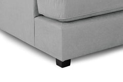 Close-up of gray sofa upholstery, stitched seat edge, and black foot
