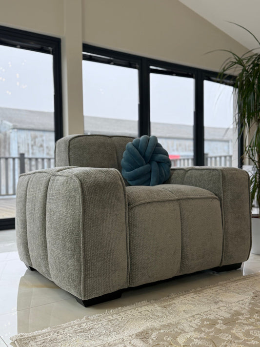Gray fullback sofa armchair with broad upholstered arms and a segmented seat