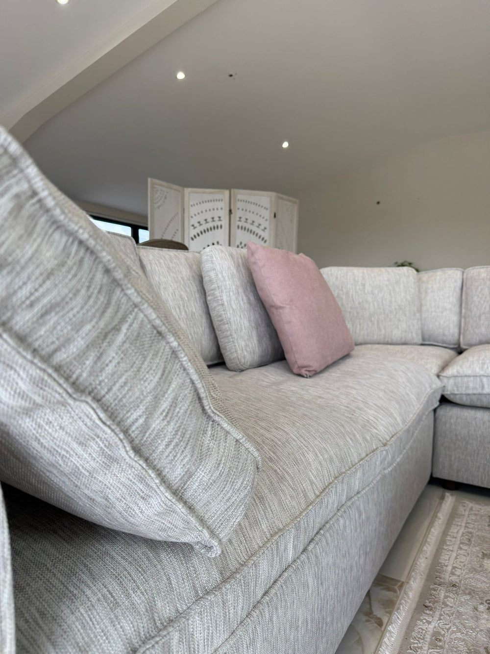 Large light gray corner sofa with deep seats and loose back cushions