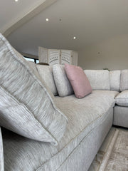 Large light gray corner sofa with deep seats and loose back cushions